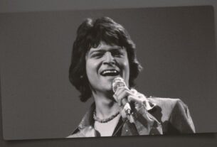 Johnny Rodriguez singing with a microphone