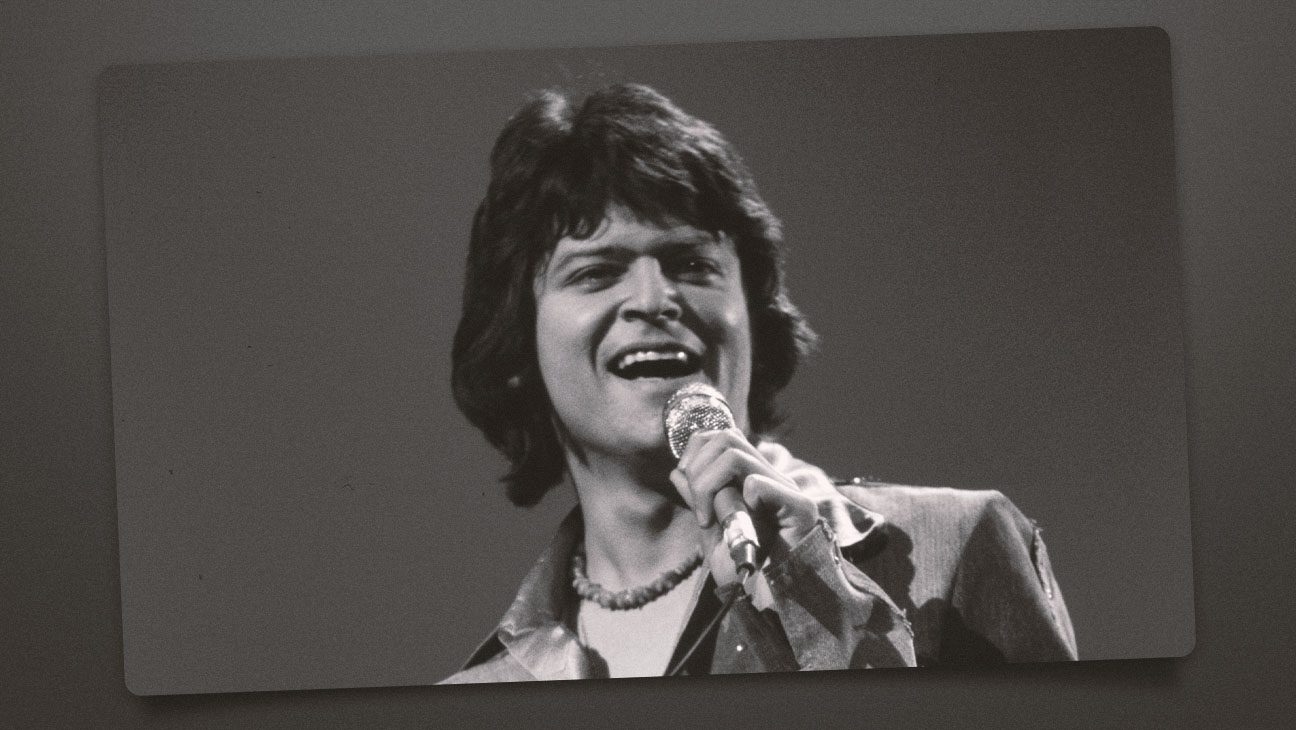 Johnny Rodriguez singing with a microphone