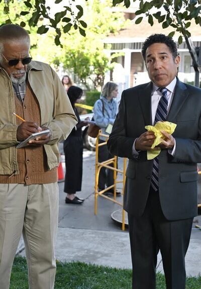 Oscar and another guy look at something off-screen.