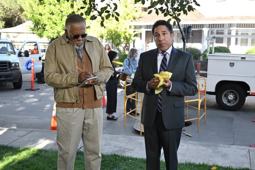 Oscar and another guy look at something off-screen.