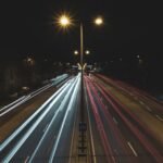 Carros em rodovia à noite, clima retrô que remete aos primeiros jogos de GTA