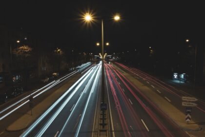 Carros em rodovia à noite, clima retrô que remete aos primeiros jogos de GTA
