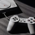 Console PlayStation com controle, usado como referência para emular PS2 no PCSX2