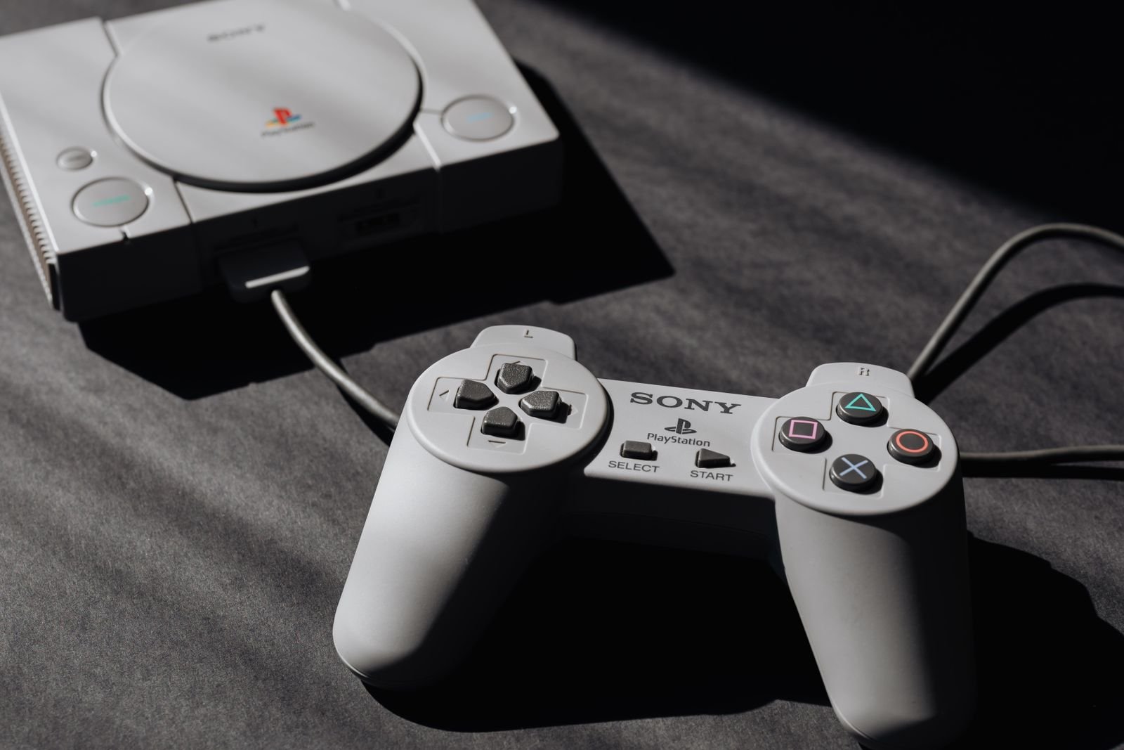 Console PlayStation com controle, usado como referência para emular PS2 no PCSX2