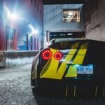 Carro esportivo em uma rua urbana à noite, clima que remete a GTA V