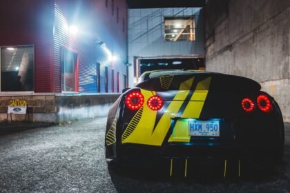 Carro esportivo em uma rua urbana à noite, clima que remete a GTA V